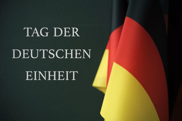 Tag der Deutschen Einheit am 3. Oktober und Fahne des Landes.