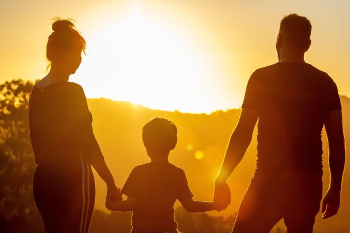 Familie blickt in den Sonnenuntergang.