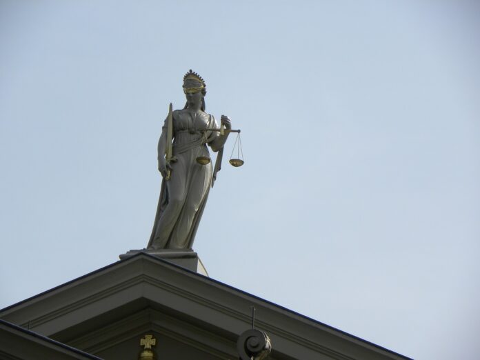 Justitia-Figur auf dem Dach eines Gerichts.