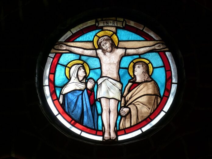 Kirchenbuntglas zeigt Jesus am Kreuz.