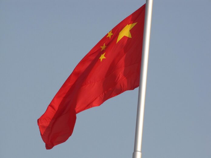 Chinesische Flagge vor grauem Himmel