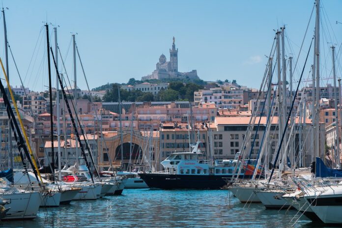 Blick durch den Hafen von Marseille. Auf dem Berg steht die Kathedrale mit der Marienstatue.