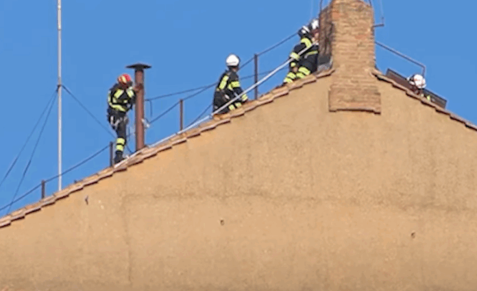 Feuerwehrleute installieren den Schornstein für die Papstwahl auf dem Dach der Sixtinischen Kapelle