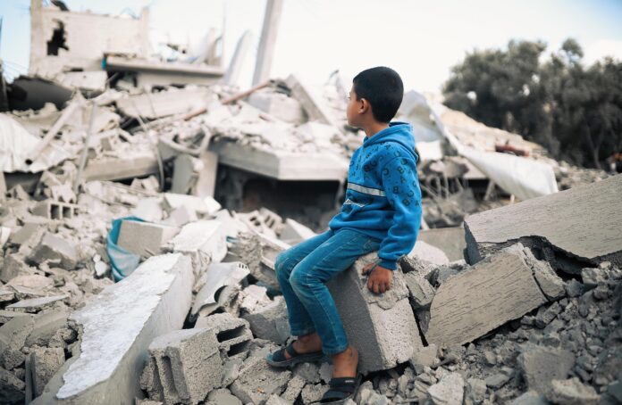 Kind sitzt in Gaza auf den Trümmern eines Hauses