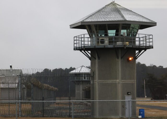 Gefängnisanlage mit Stacheldrahtzaun und Wachturm