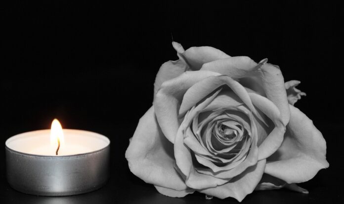 Ein Teelicht brennt und eine Rose in schwarz-weiß.