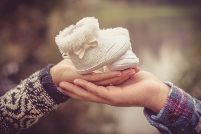 Elternpaar hält Babyschuhe
