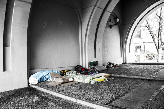 Decken und Schlafsäcke von Obdachlosen unter einer Brücke.
