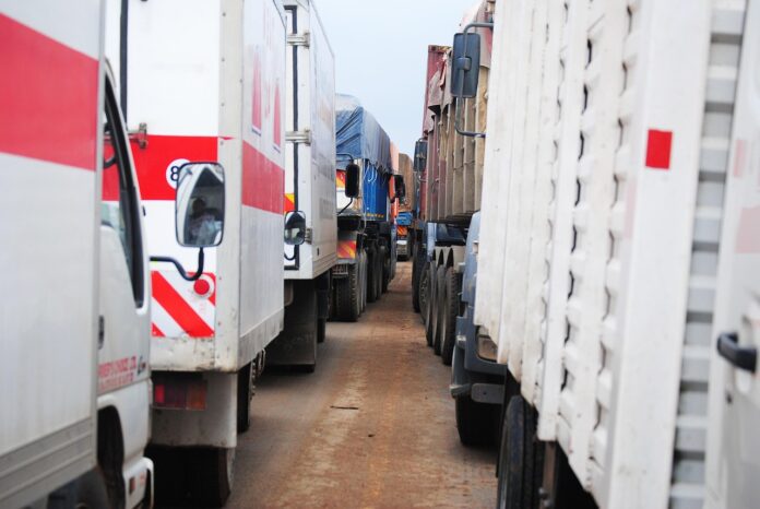 Viele LKW stehen in zwei Reihen und warten