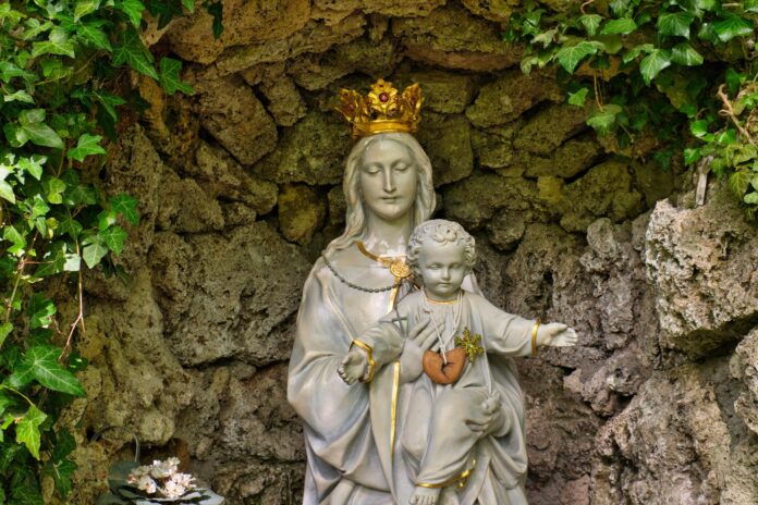 Maria mit einer goldenen Krone und das Jesuskind in einer Grotte